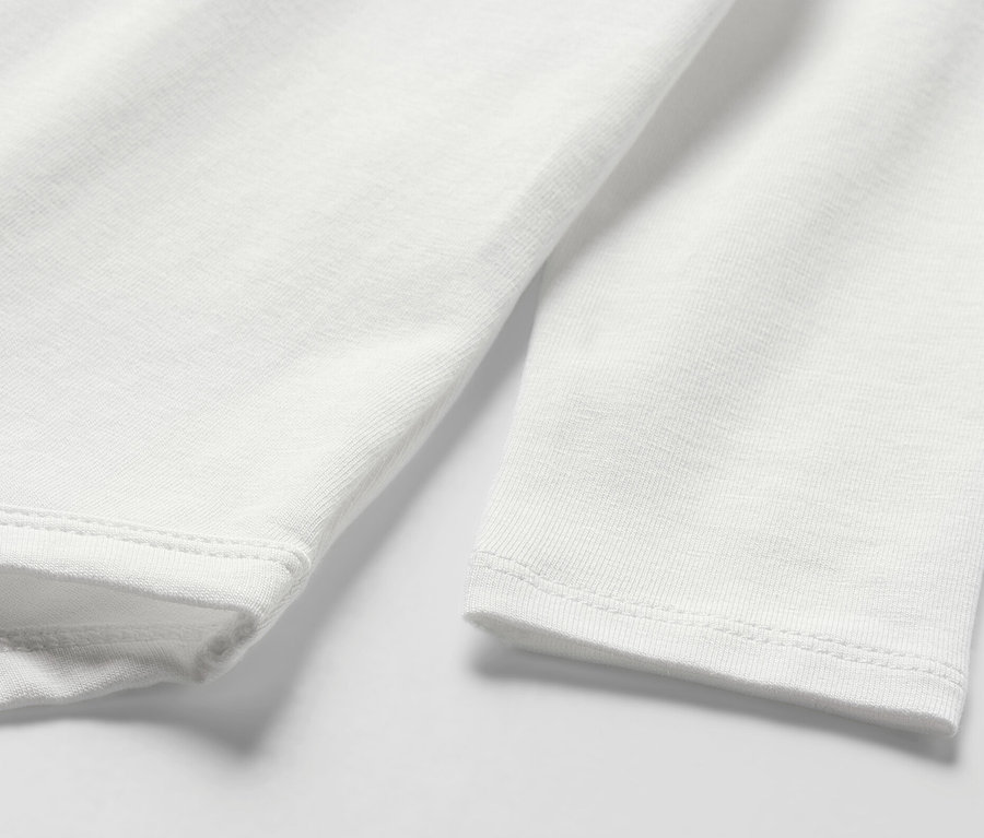 Gros plan sur un body blanc à manches longues pour bébé.