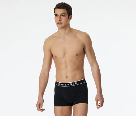 Homme torse nu portant un shorty SCHIESSER noir avec ceinture blanche.