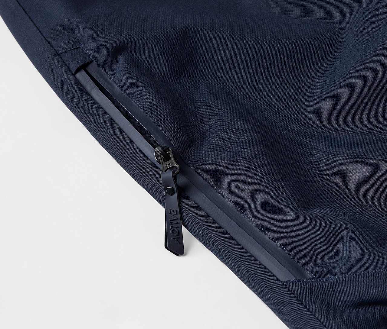 Gros plan sur une veste bleu foncé avec fermeture éclair et logo.