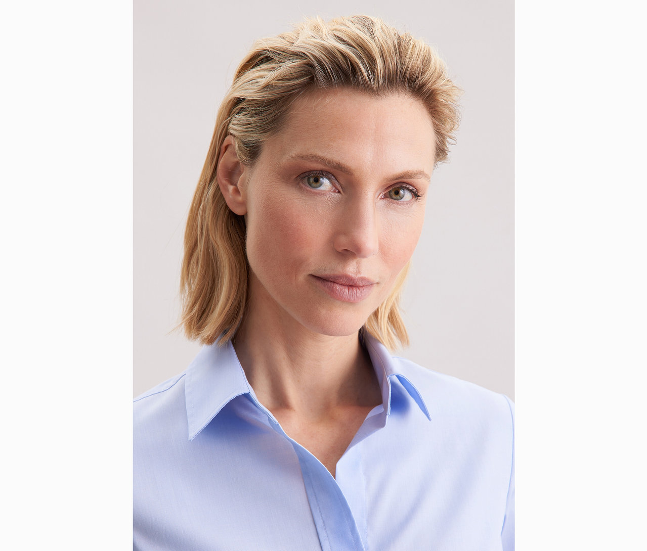 Femme portant un chemisier bleu clair Slim Fit non iron Seidensticker.