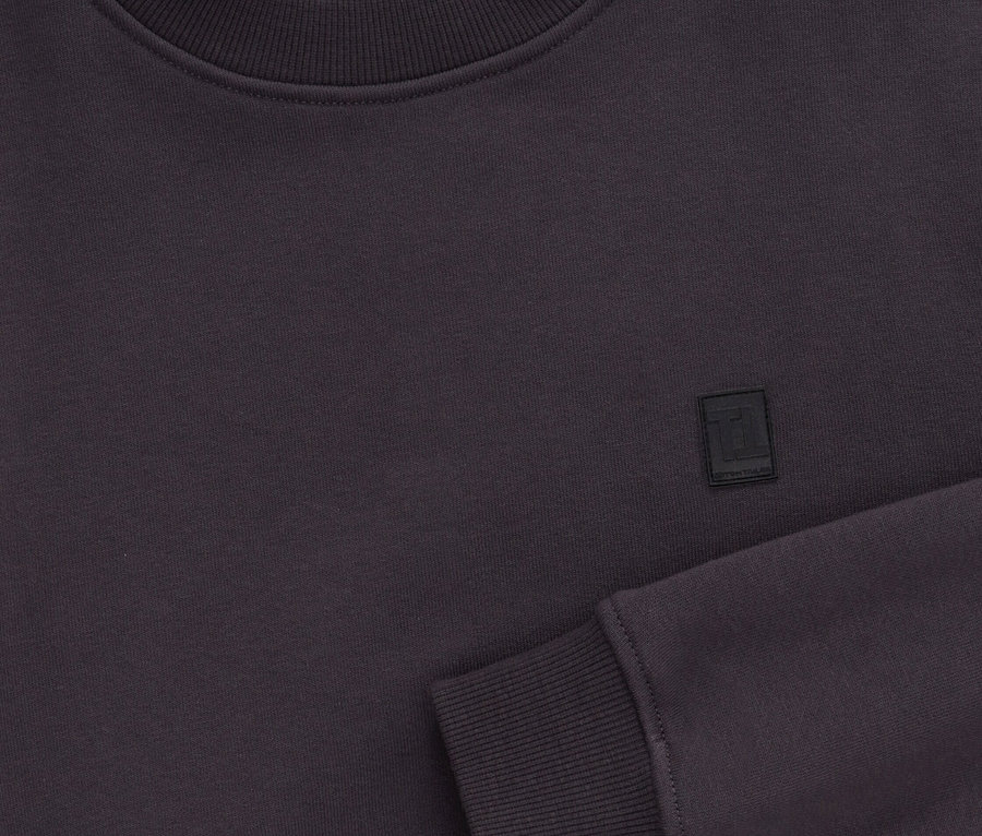 Gros plan d'un sweat-shirt à manches longues violet foncé en coton biologique.