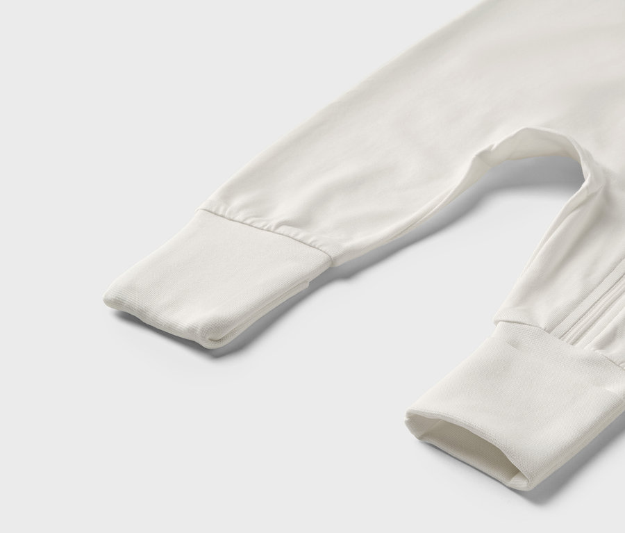 Gros plan sur un pyjama bébé blanc/vert.