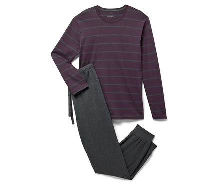 Un pyjama violet rayé à manches longues et un pantalon de pyjama gris sont posés sur un fond blanc.