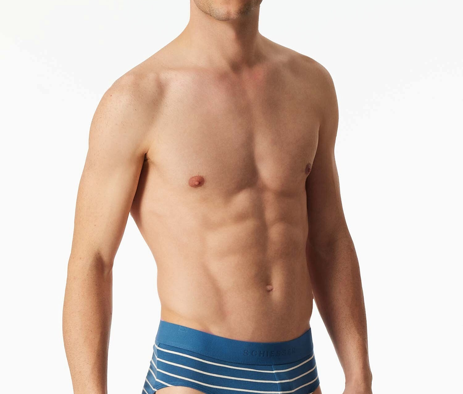 Homme torse nu posant en slip rayé bleu et blanc.