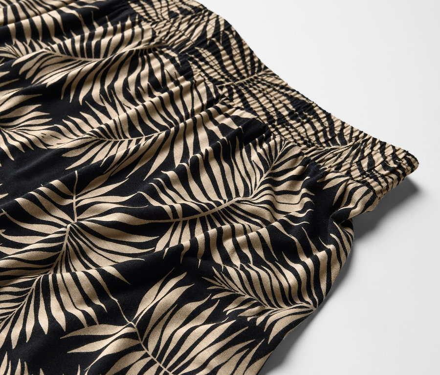 Gros plan sur le motif imprimé de feuilles d'une robe en jersey.