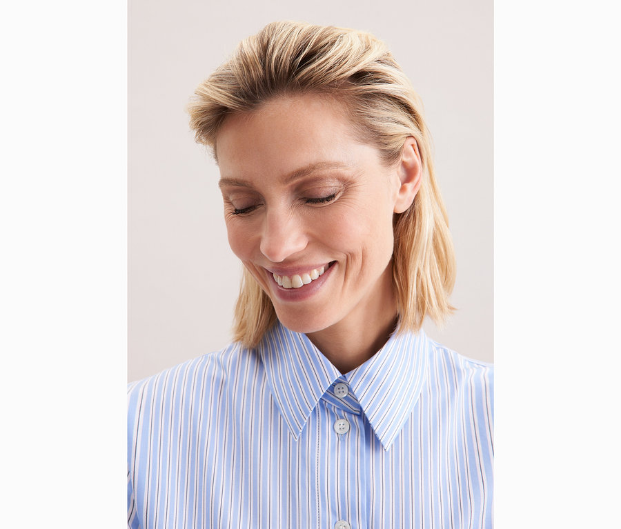 Femme portant une chemise oversize rayée bleu et blanc Seidensticker.