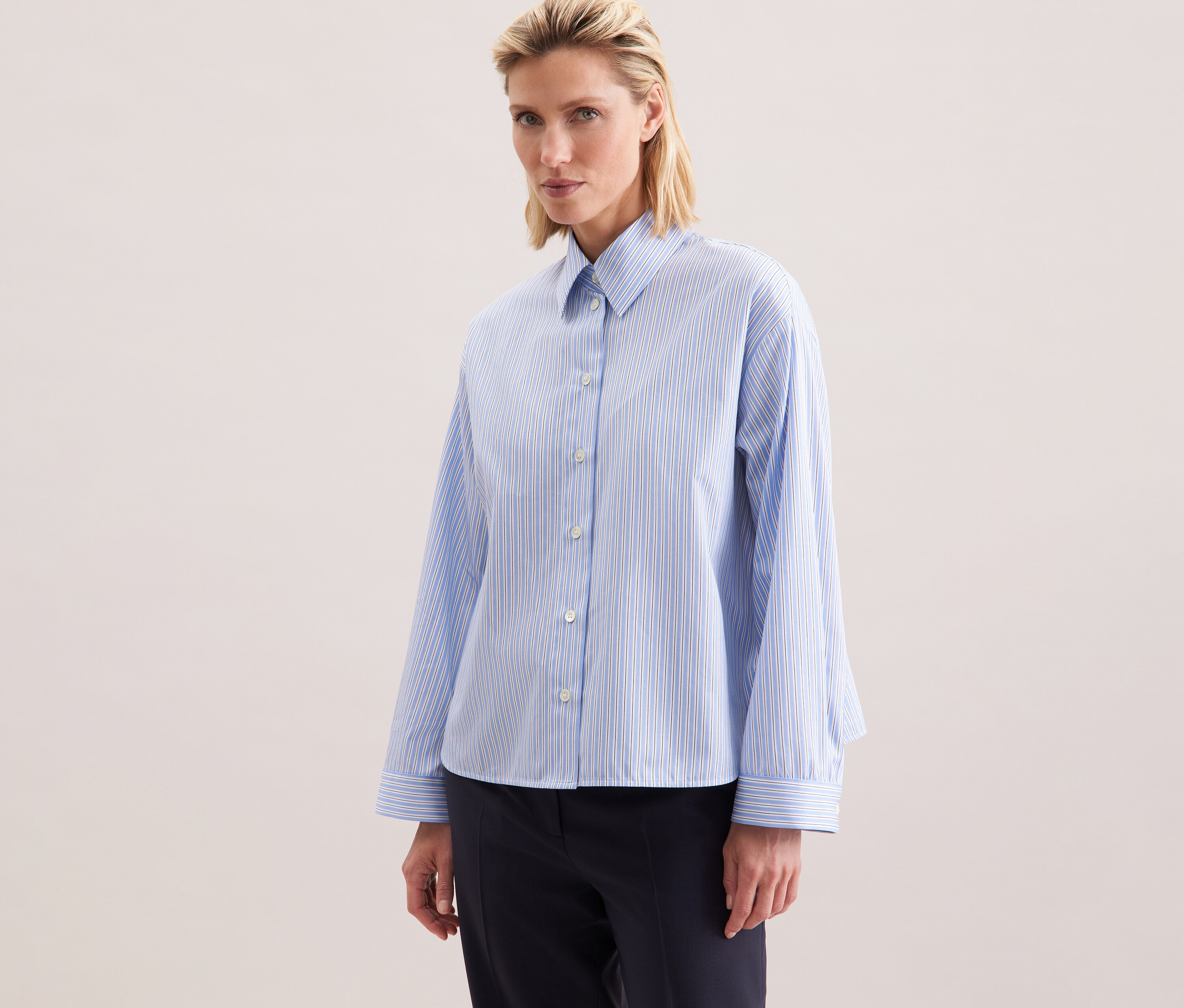 Femme portant une chemise oversize Seidensticker à rayures bleues.