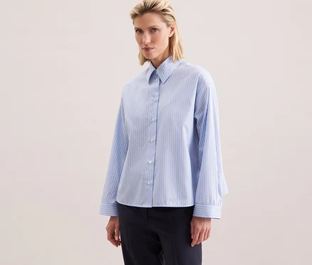 Femme portant une chemise oversize Seidensticker à rayures bleues.