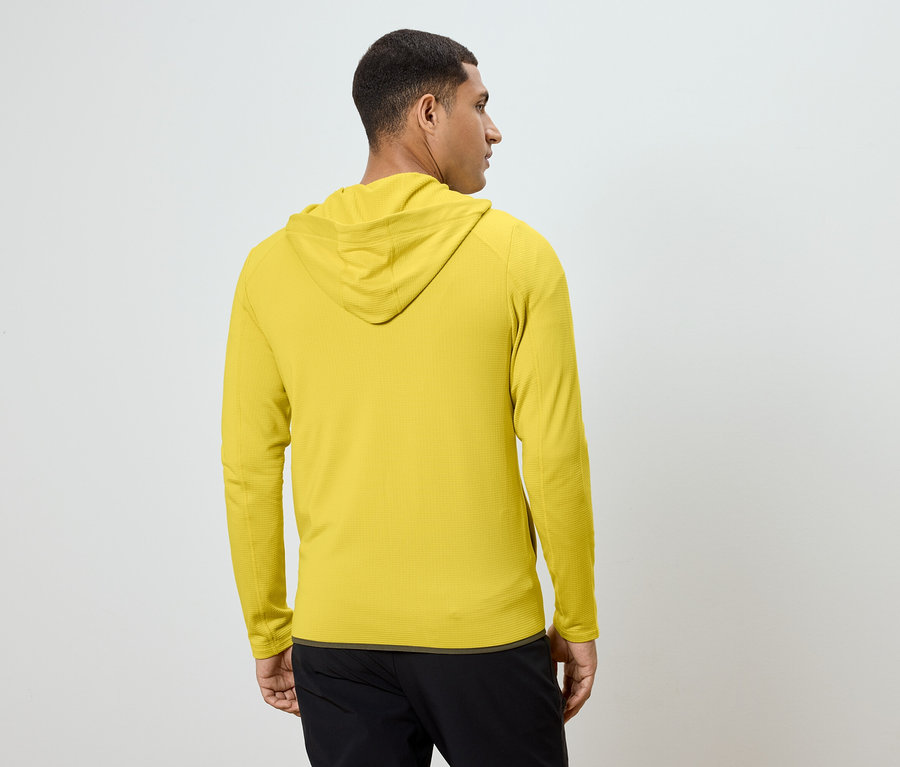 Homme vu de dos portant un sweat à capuche jaune et un pantalon noir.