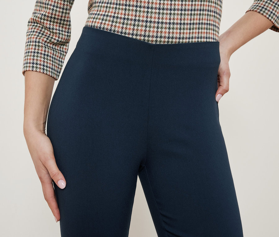 Haut d'une tenue pour femme avec un chemisier à carreaux et des leggings bleu marine.