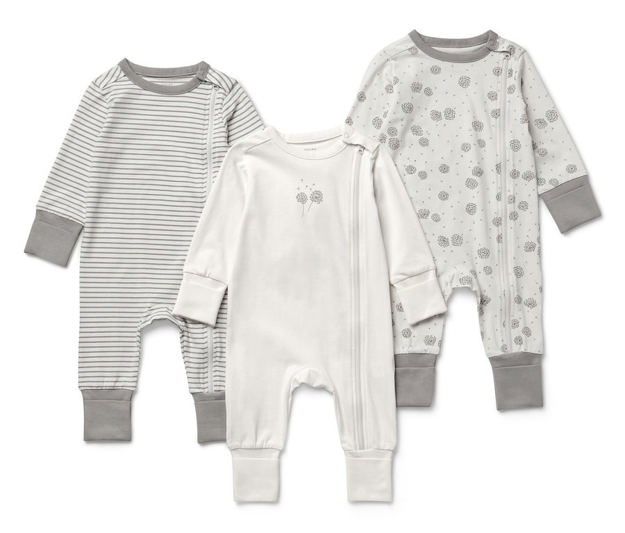 Trois pyjamas pour bébé sont posés sur un fond blanc.