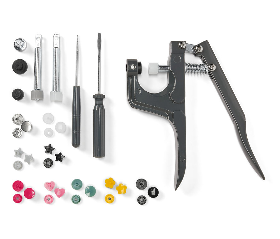 Kit de boutons-pression avec divers outils sur fond blanc.