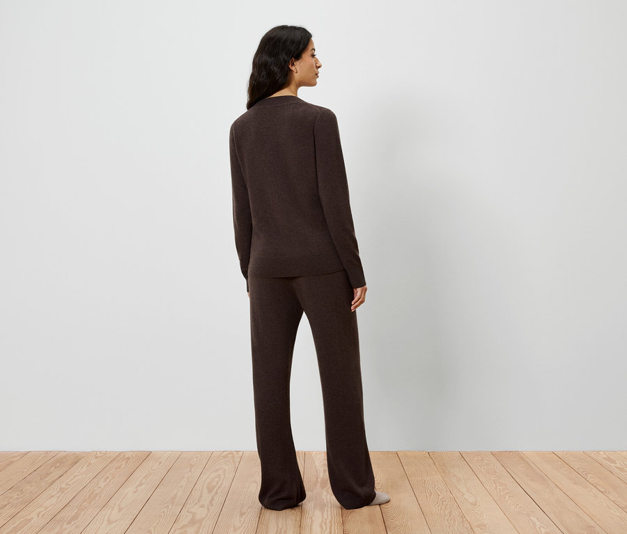 Vue arrière d'une femme portant un pull et un pantalon en tricot marron.