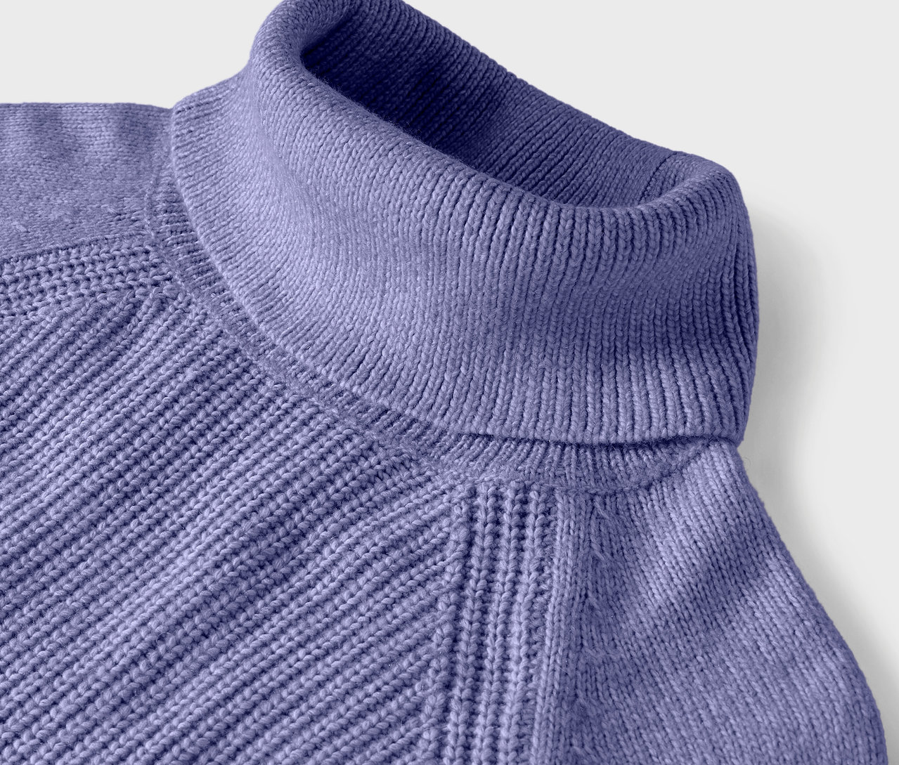Gros plan d'un pull à col roulé violet avec un motif côtelé.