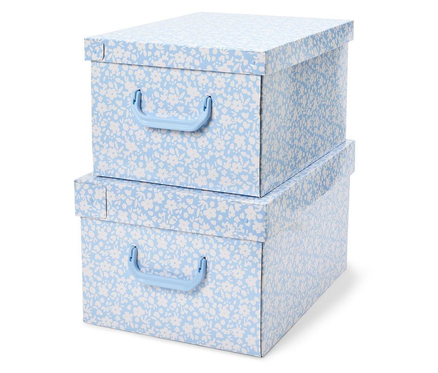 Deux boîtes de rangement empilées avec un motif floral bleu et des poignées bleues.