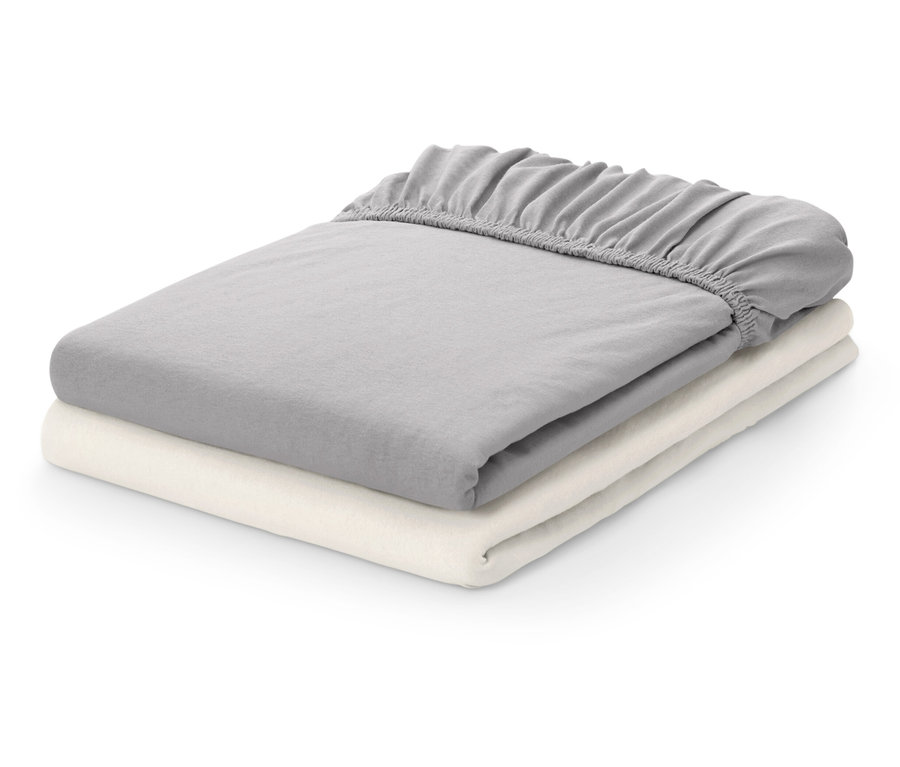Deux draps-housses pliés : un gris et un crème.