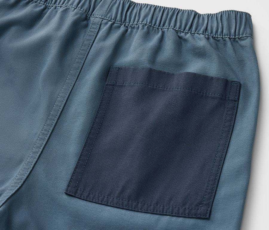 Détail d'un bermuda pour enfant avec taille élastique et poche arrière.