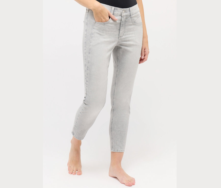 Une femme porte un jean gris clair Angels «	Ornella Seam	» Slim Fit 7/8.