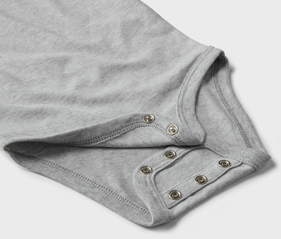 Gros plan sur un body gris évolutif pour bébé avec des boutons-pression.