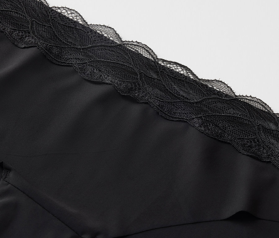 Gros plan sur un tissu noir avec de la dentelle noire sur le bord.