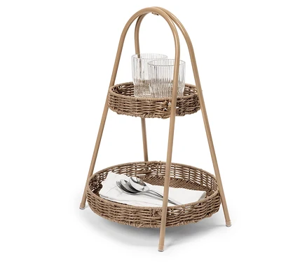 Un chariot de service à deux niveaux en osier avec deux verres dans le panier supérieur et des serviettes et des couverts dans le panier inférieur.