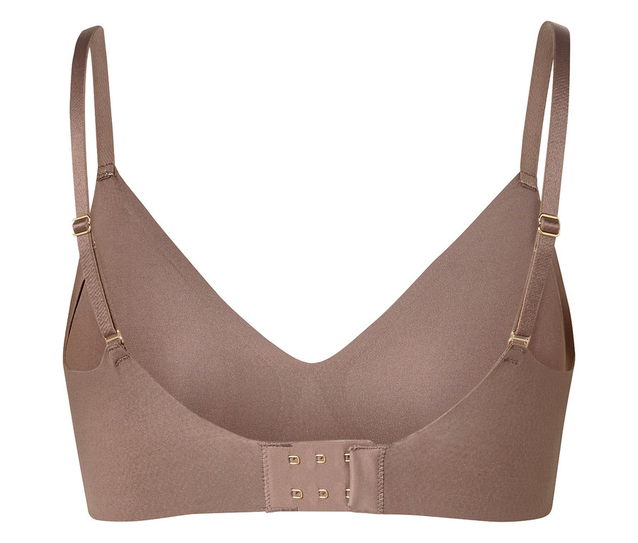 Gros plan d'un soutien-gorge beige avec bretelles réglables et fermeture à agrafes dans le dos.