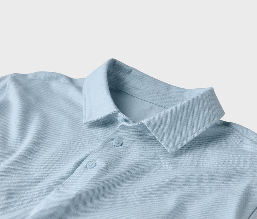 Gros plan d'un polo bleu clair avec un col et deux boutons.