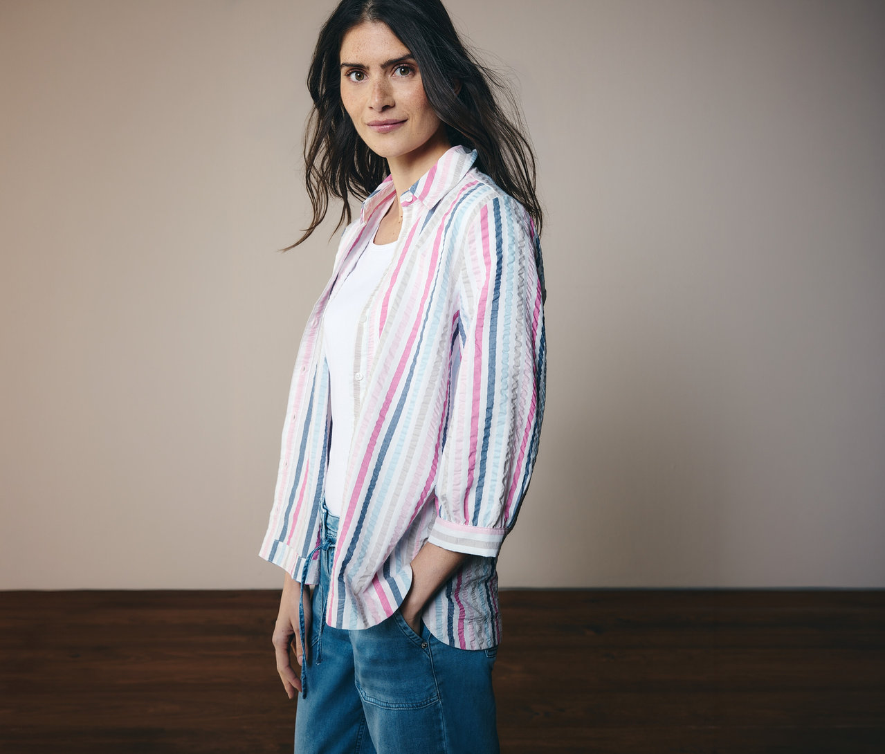 Femme portant un chemisier CECIL rayé avec des manches 3/4 et un jean. Elle a une main dans sa poche.