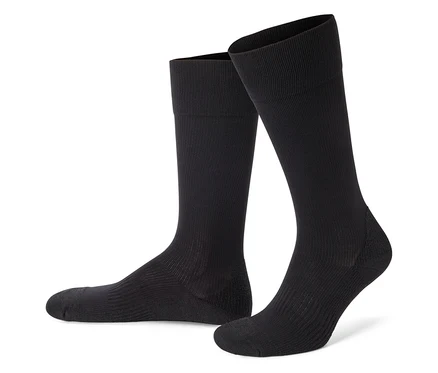 Deux chaussettes montantes noires côtelées se tiennent sur un fond blanc.
