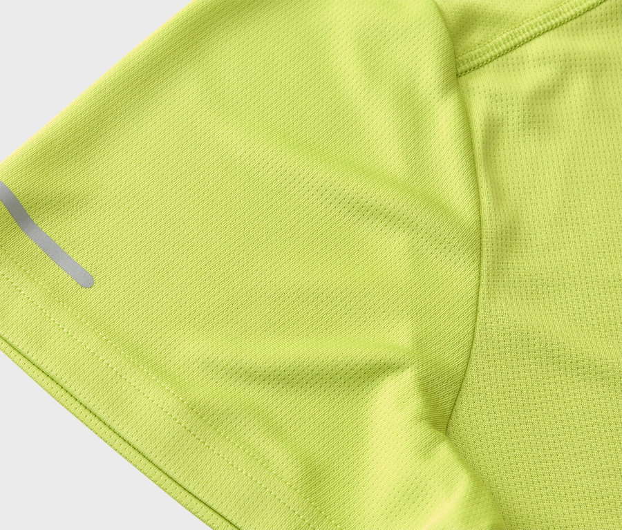 Gros plan sur la manche d'un t-shirt de sport vert clair avec une bande réfléchissante.