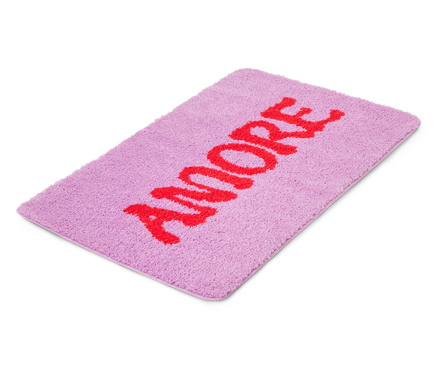 Un tapis de bain violet avec le mot rouge "AMORE" dessus.
