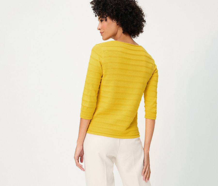 Femme de dos portant un pull-over structuré Olsen à manches 3/4 jaune et un pantalon blanc.