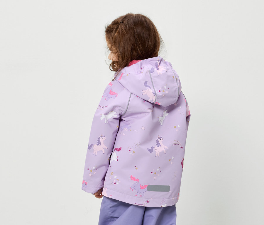 Vue de dos, une enfant aux cheveux bruns porte une veste lilas à motifs de licornes et un pantalon assorti.