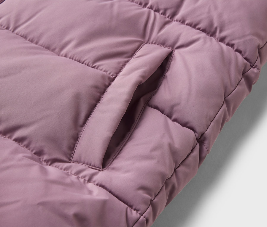 Gros plan d'une veste matelassée violette avec une poche ouverte.