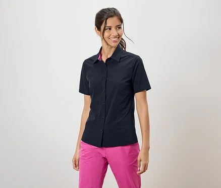 Femme portant une chemise bleu marine à manches courtes et un pantalon rose.