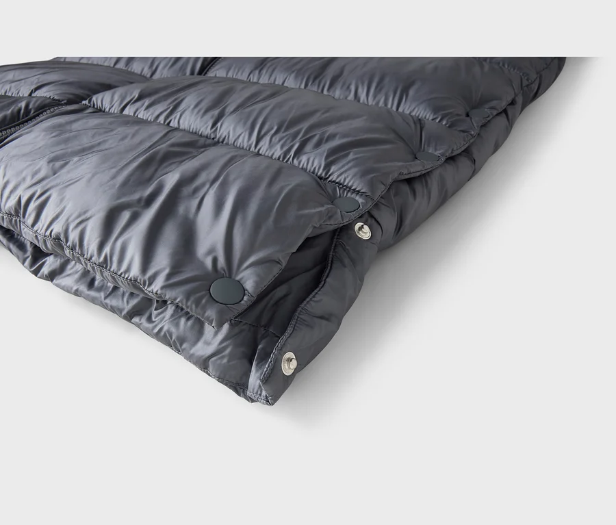 Tissu matelassé gris foncé avec boutons-pression.
