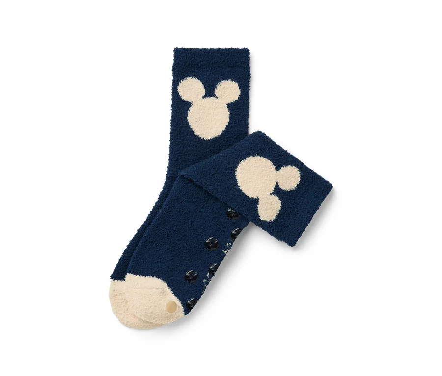 Deux chaussettes bleu marine avec des motifs Mickey Mouse crème et des éléments antidérapants sur les semelles.