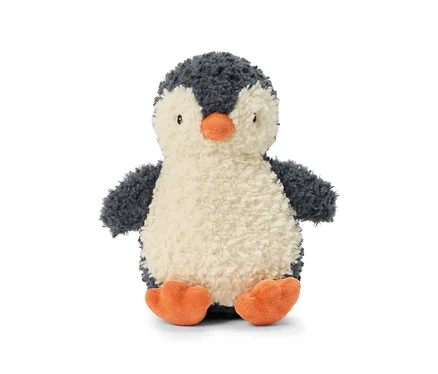 Une peluche pingouin moelleuse assise et tournée vers l'avant. Elle a une tête et un dos gris foncé, un ventre crème, de petits yeux noirs, un bec orange et des pattes palmées orange.