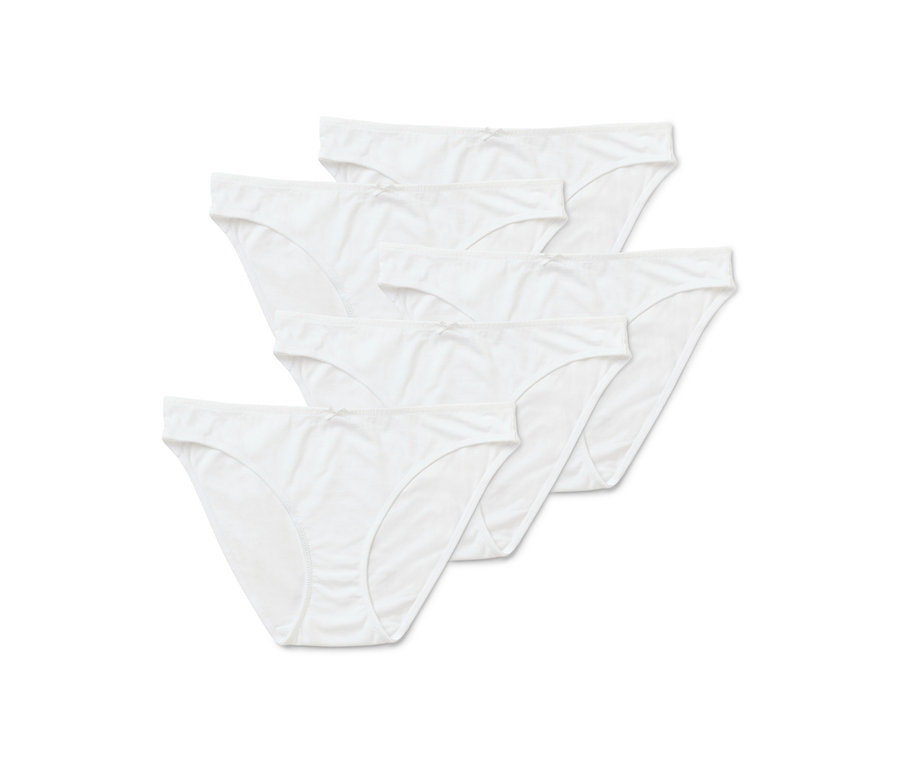 Cinq culottes blanches pour femmes sont posées les unes sur les autres.