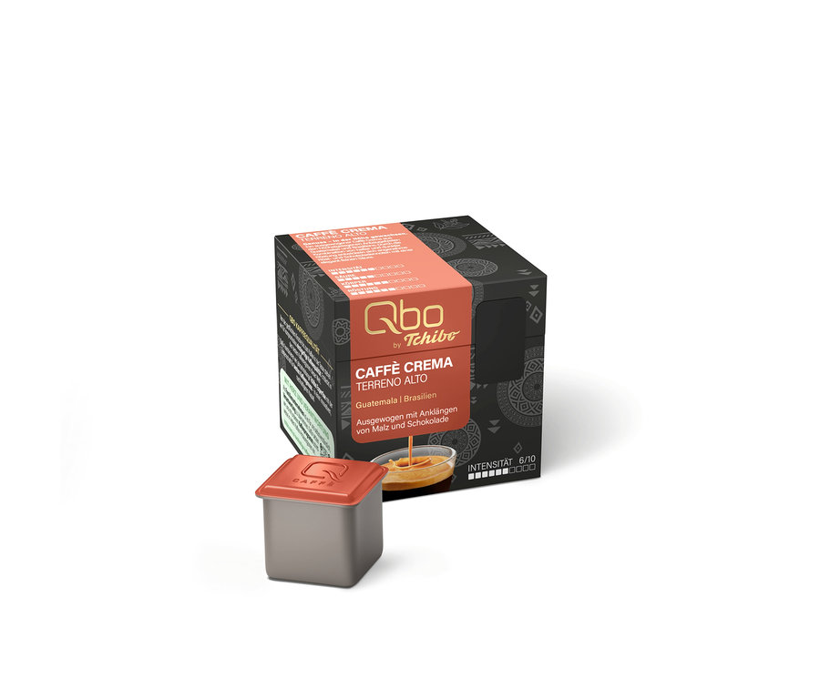 Un emballage de capsules Qbo Caffè TERRENO ALTO gris foncé avec une bande orange et une capsule grise individuelle avec un couvercle orange. Sur l'emballage, du café est représenté coulant d'une capsule dans un bol.