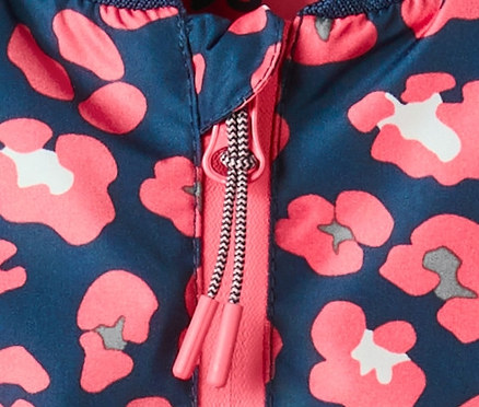 Gros plan sur une veste pour tous les temps de style bomber avec un motif floral et une fermeture éclair.