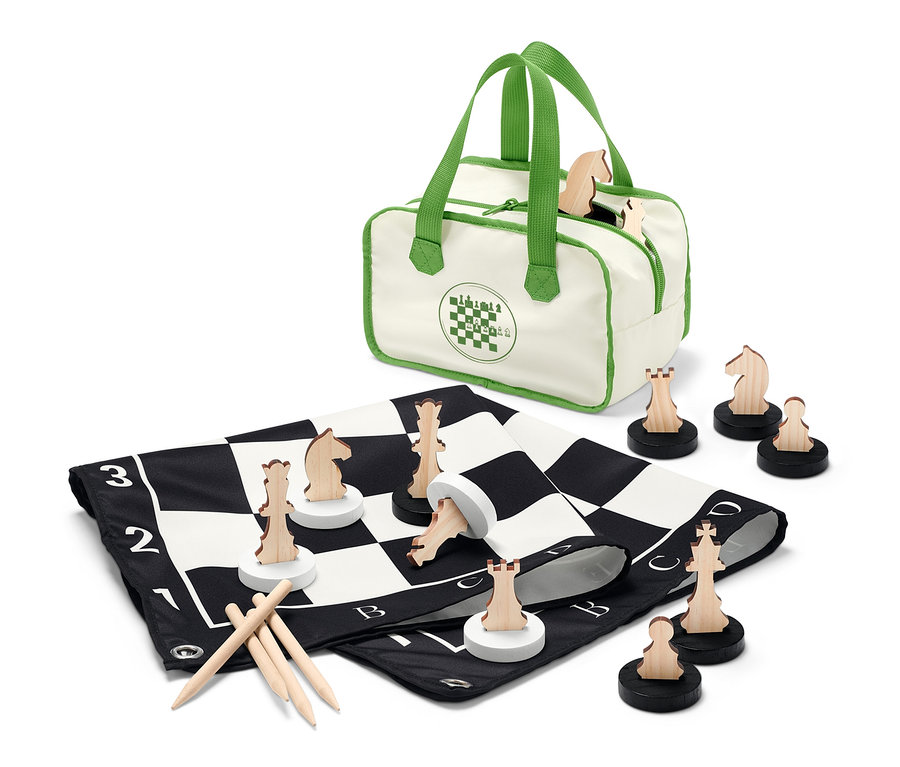 Un jeu d'échecs XL est étalé avec des pièces d'échecs en bois et un sac.