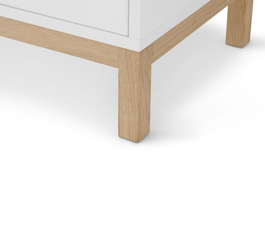 Détail d'une commode « Eklund » avec tiroirs et porte, montrant les pieds du meuble.