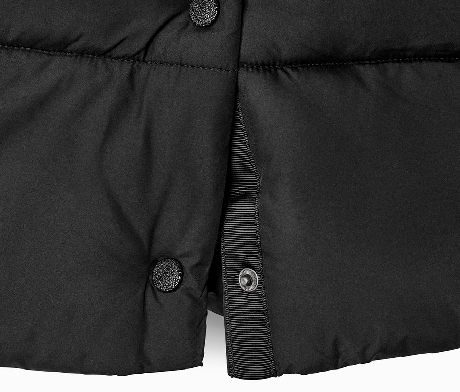 Détail d'un manteau matelassé noir à capuche avec boutons.