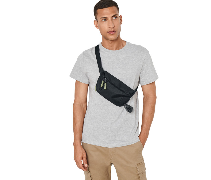 Un homme porte un sac de promenade pour chien noir.