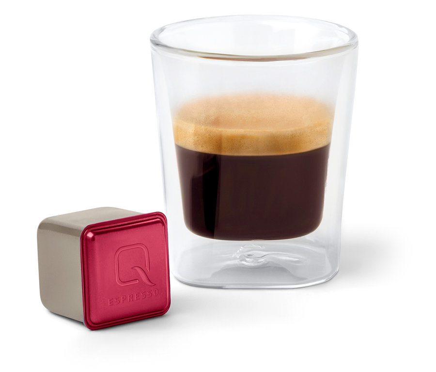 Sur un fond blanc, un verre d'espresso est placé à côté d'une capsule Qbo Espresso SIDAMA ROYAL.