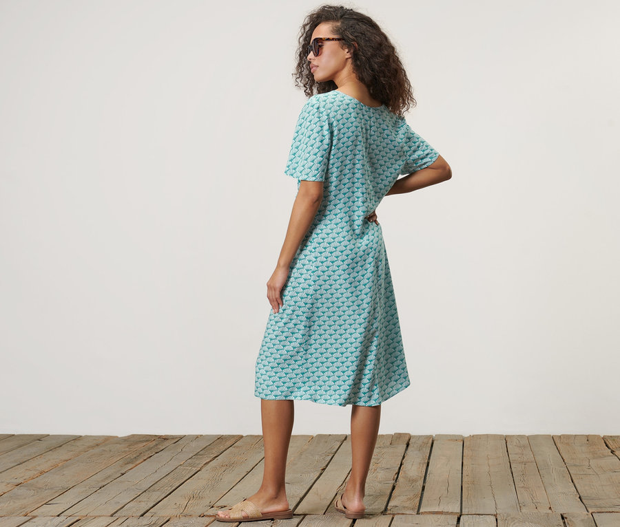 Femme posant dans une robe à imprimé.
