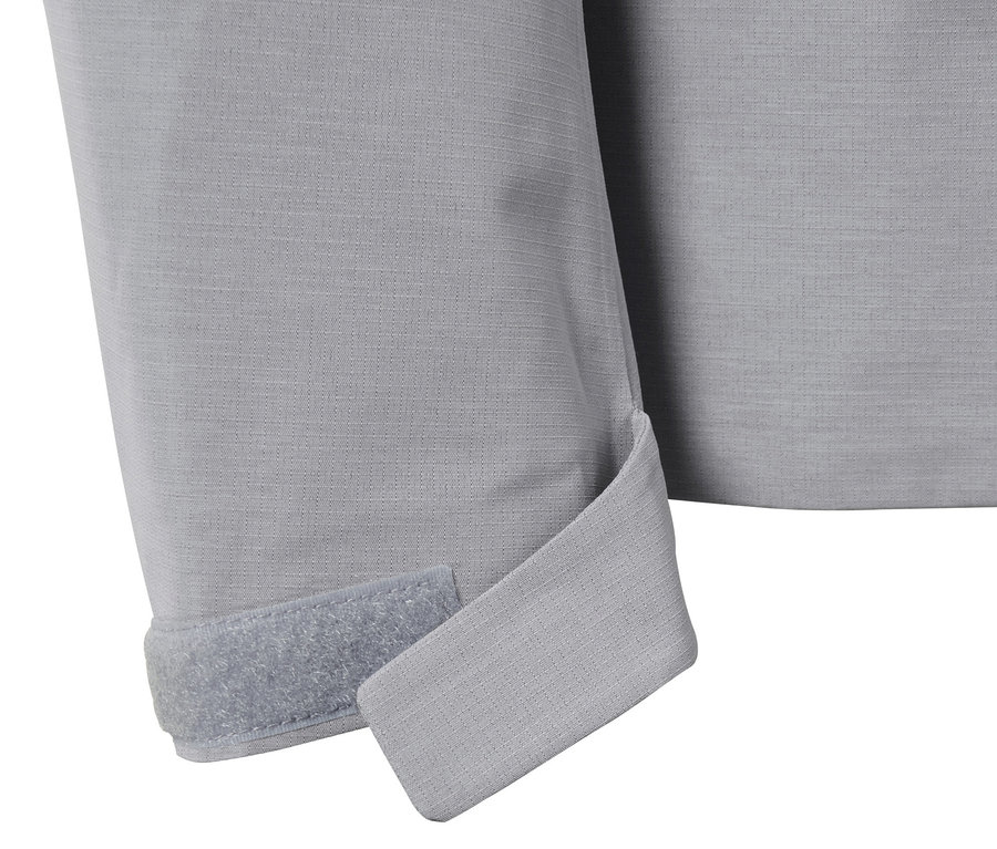 Gros plan sur une veste d'extérieur technique grise avec une fermeture velcro sur la manche.