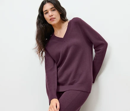 Femme posant en pull en maille.