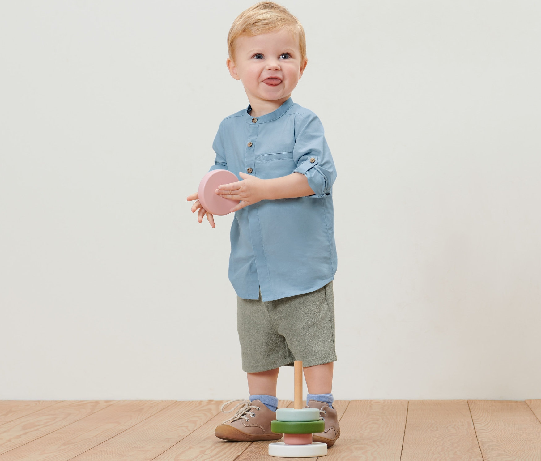 Garçon en chemise pour enfant tenant un jouet.